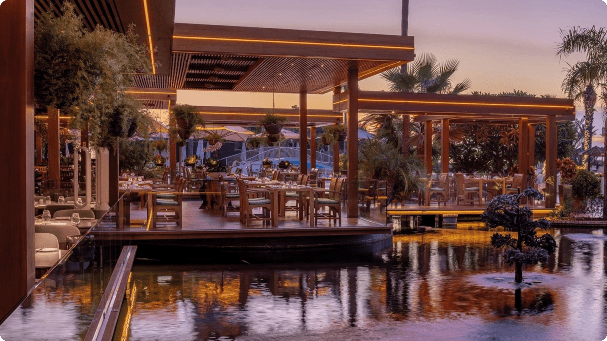 Outdoor dining area by a reflective pool.