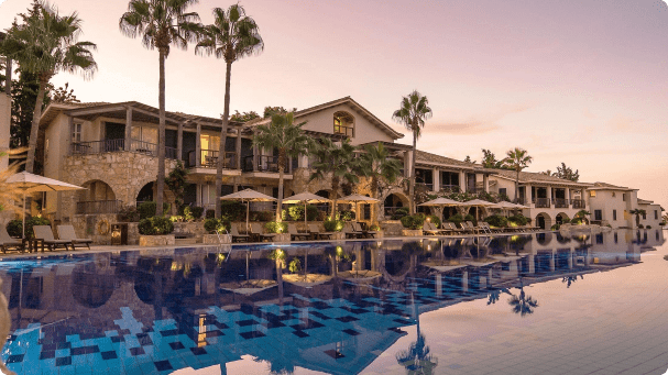 Luxury resort with a large pool at sunset.