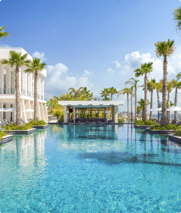 Luxury resort pool with palm trees.