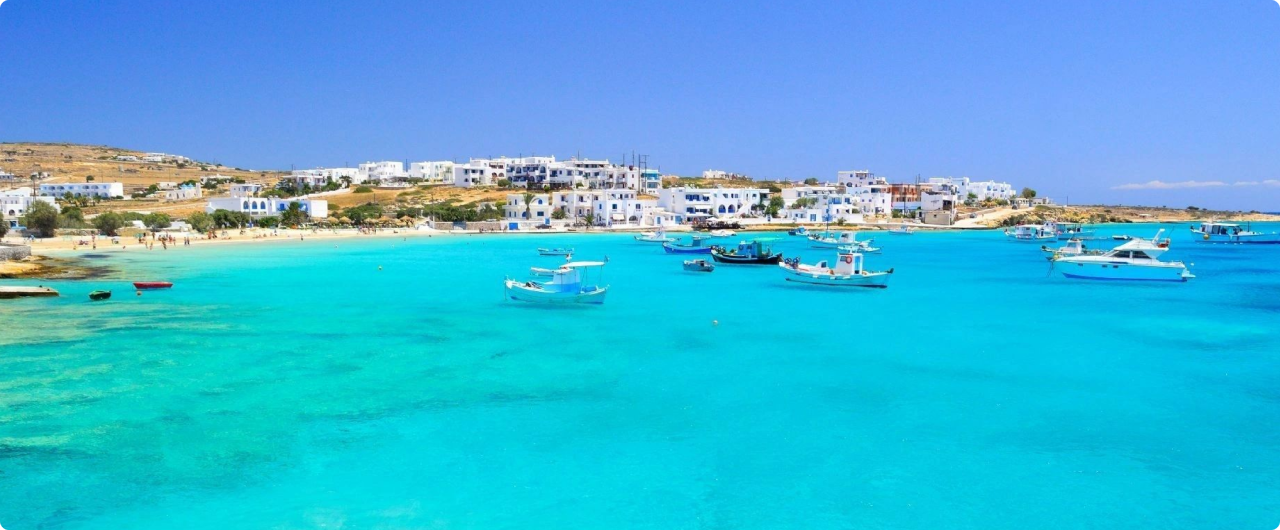 Coastal village with boats and turquoise water.