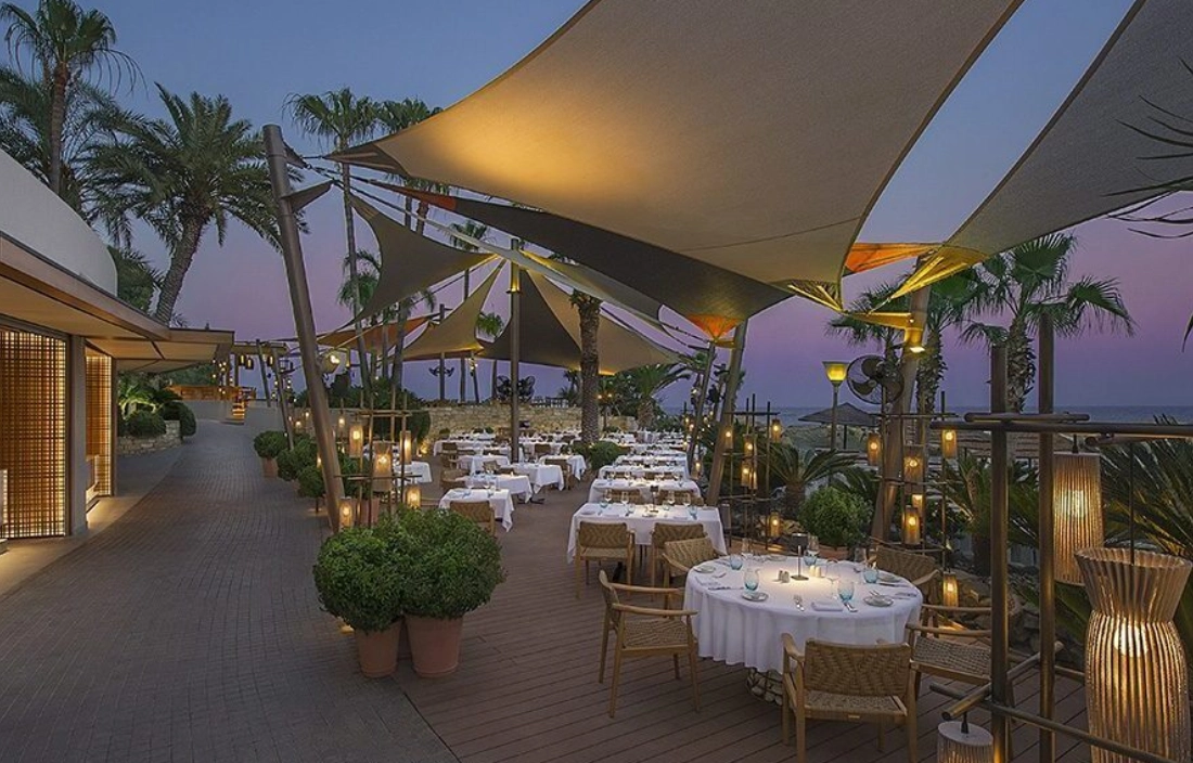 Elegant outdoor dining area with canopy lighting at dusk.