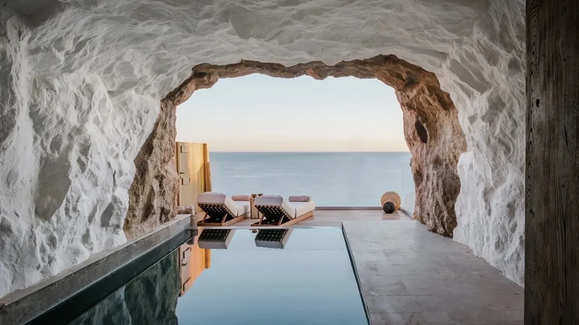 Luxurious poolside cave with ocean view and lounge chairs.