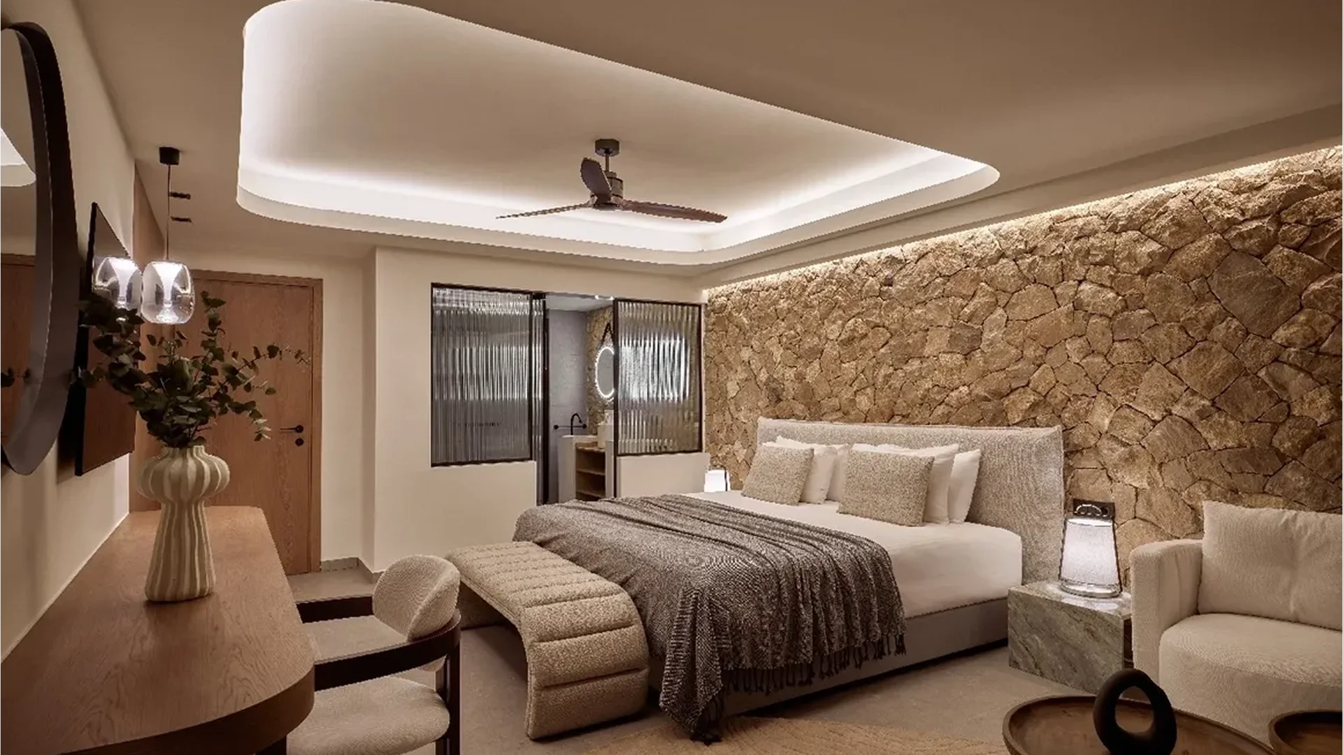 Cozy modern bedroom with stone accent wall and ambient lighting.