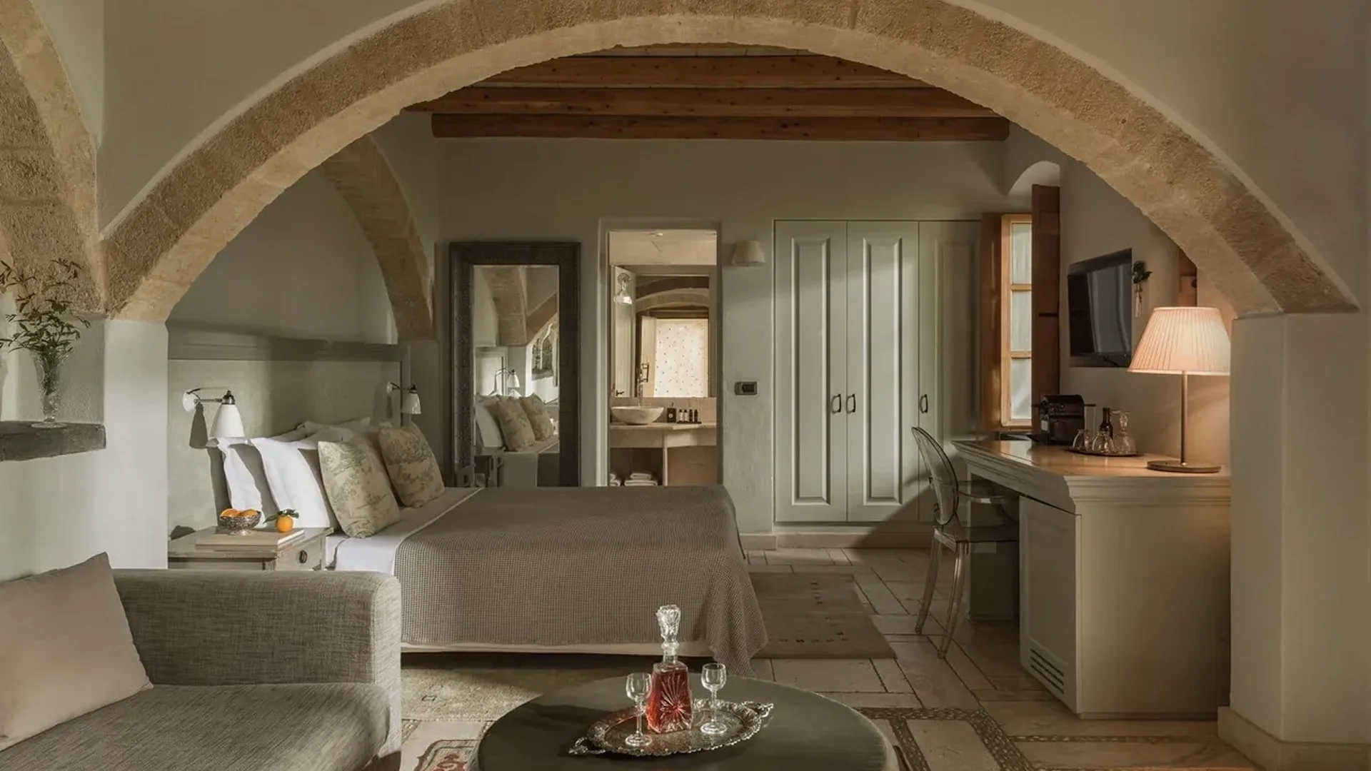 Cozy bedroom with rustic stone walls and wooden beams.