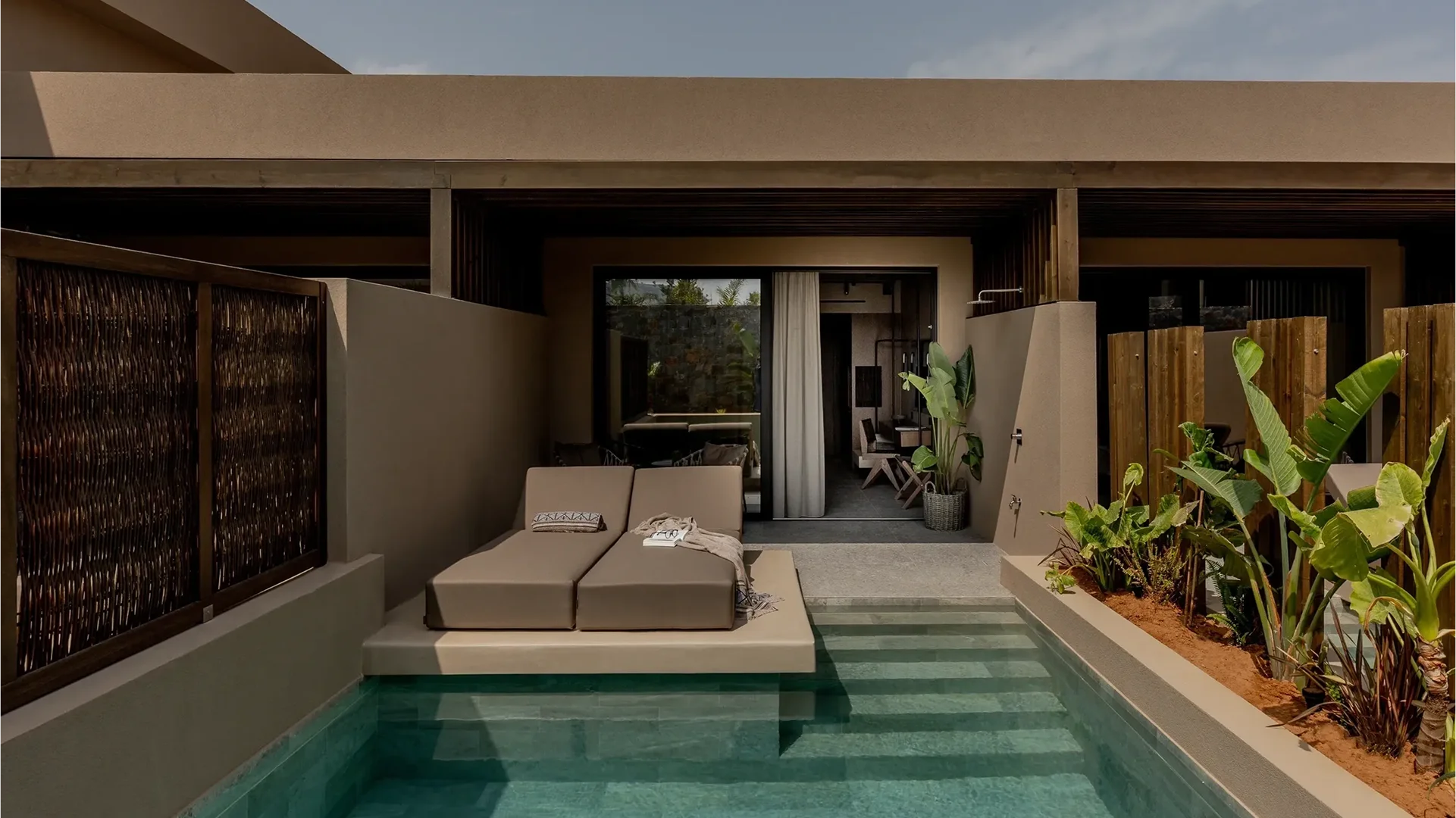 Modern outdoor patio with lounge chairs and a private pool.