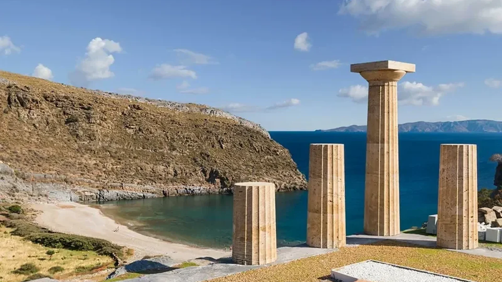 Ancient Greek ruins overlooking a serene coastal landscape with blue sea and sky.