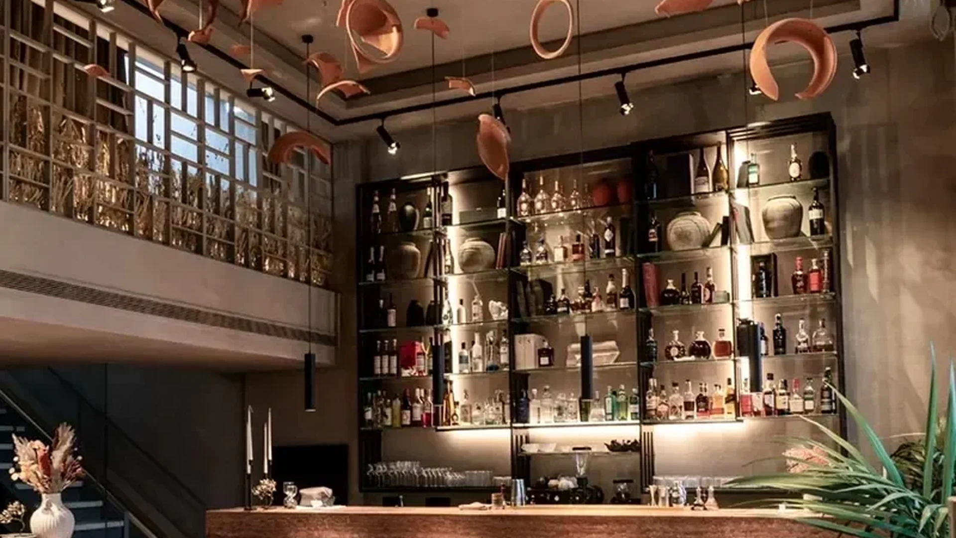 Cozy bar interior with warm lighting and shelves of bottles.