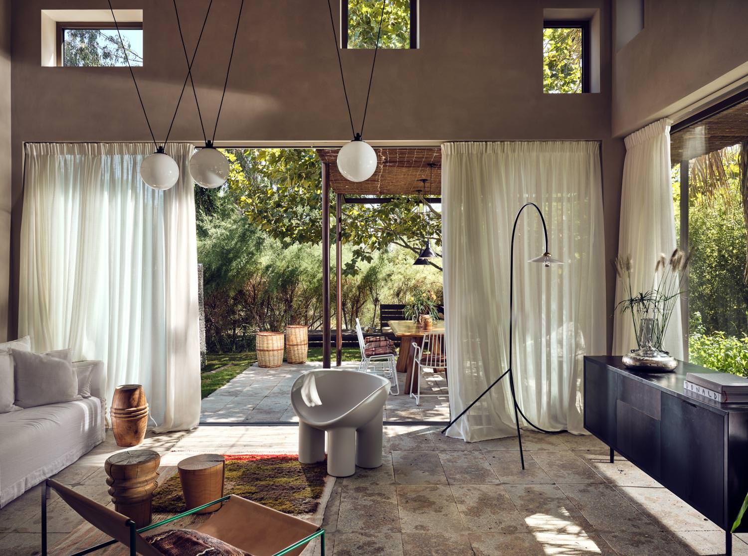 Cozy living room with large windows opening to a lush garden.