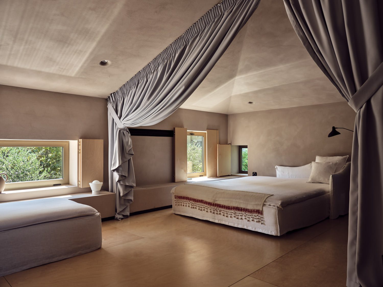 Elegant bedroom with draped canopy and soft natural light.