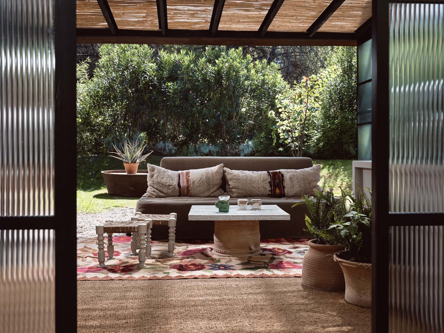 Cozy patio with cushioned seating and lush greenery.