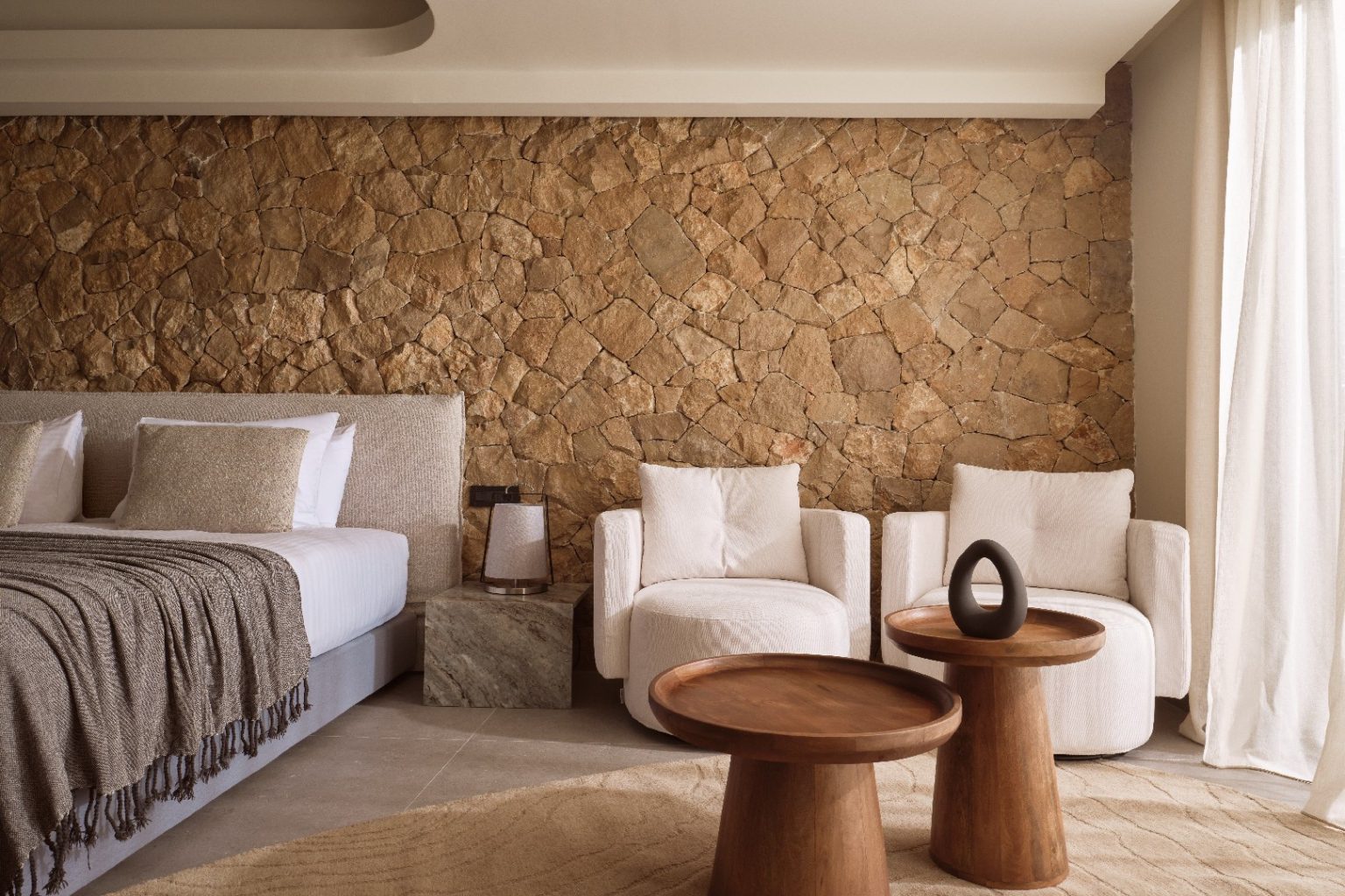 Cozy living room with natural stone wall and modern furniture.