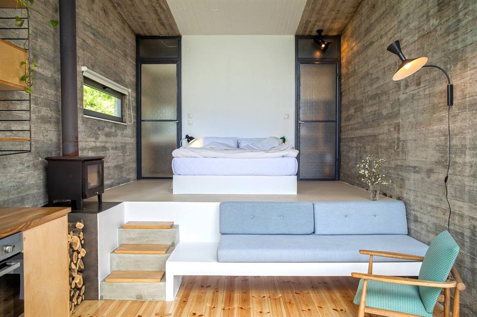 Minimalist bedroom with a floating bed and modern seating area.