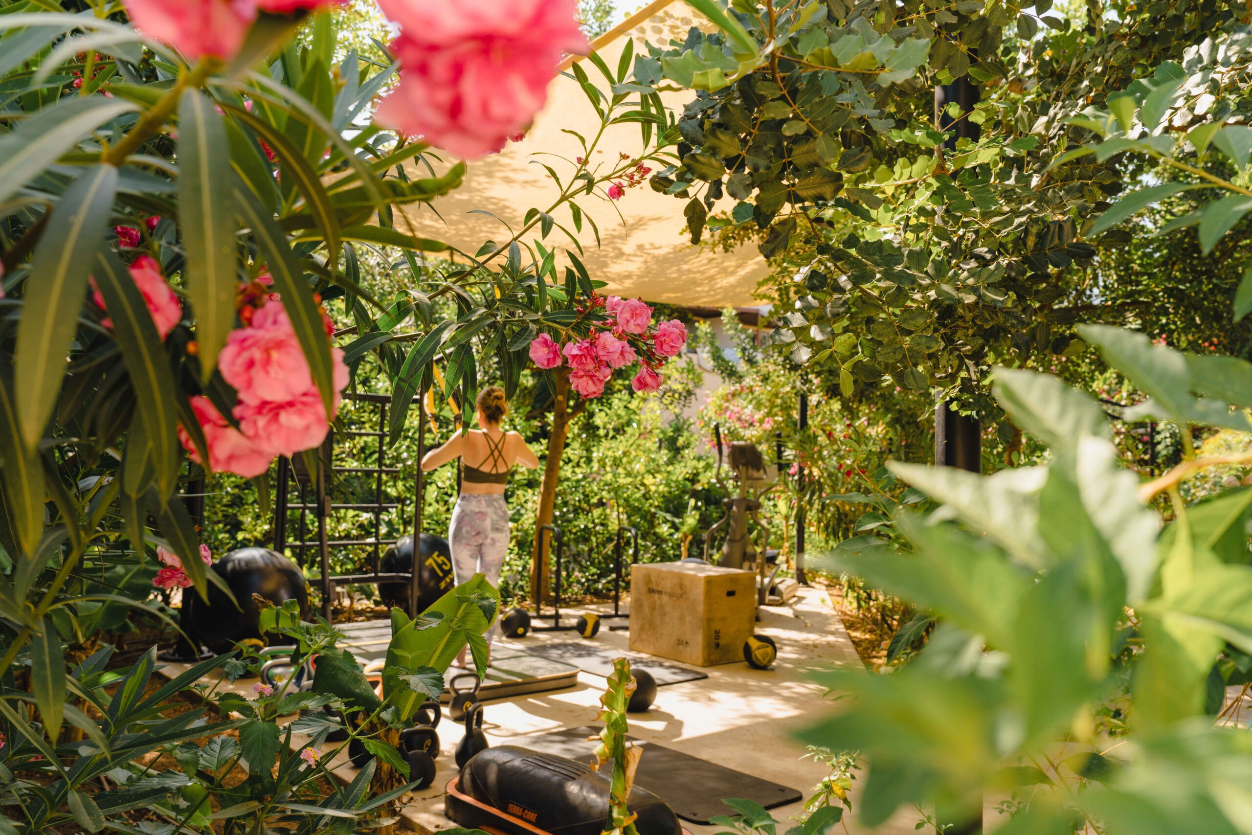 A vibrant garden patio with blooming pink flowers and cozy seating.
