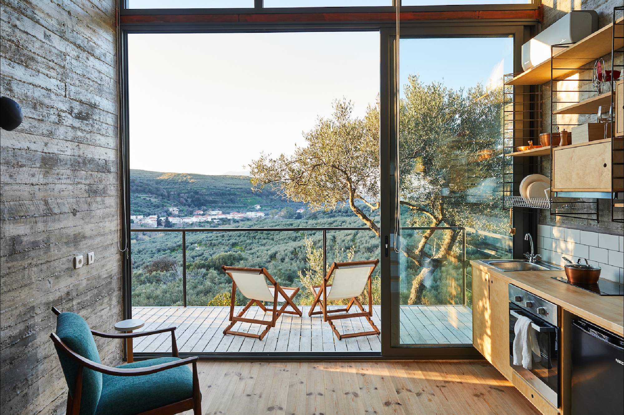 Cozy balcony with chairs overlooking a serene lakeside landscape.