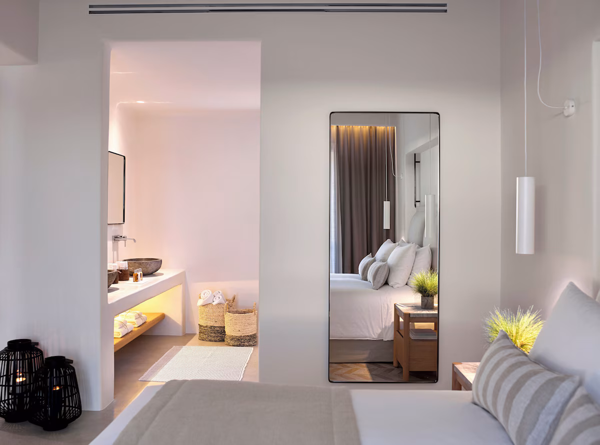 Modern bedroom with an open bathroom and elegant decor.