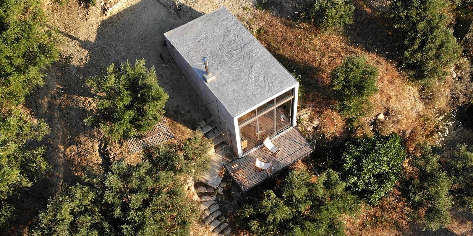Modern small house with rooftop terrace in a wooded area.