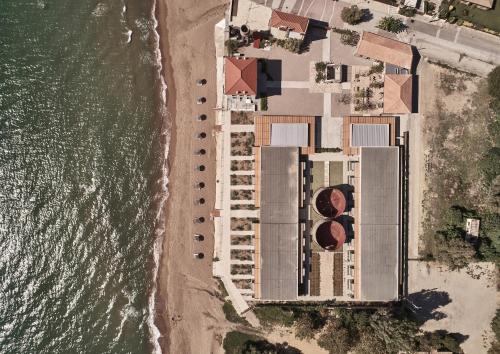 Aerial view of beachfront resort with pools and lounging areas.