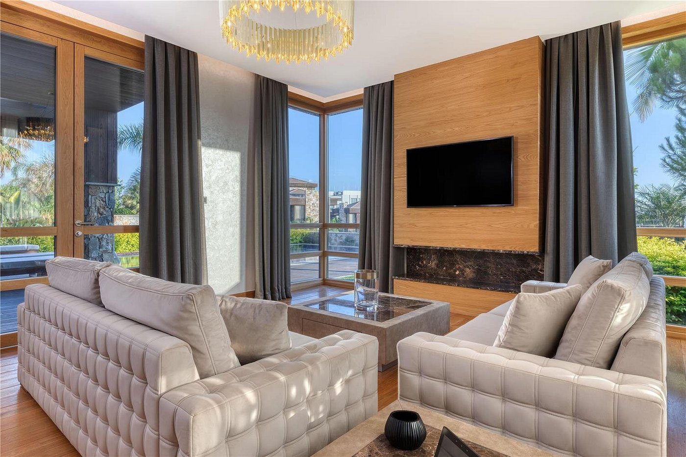 Modern living room with plush sofas and a wall-mounted TV.