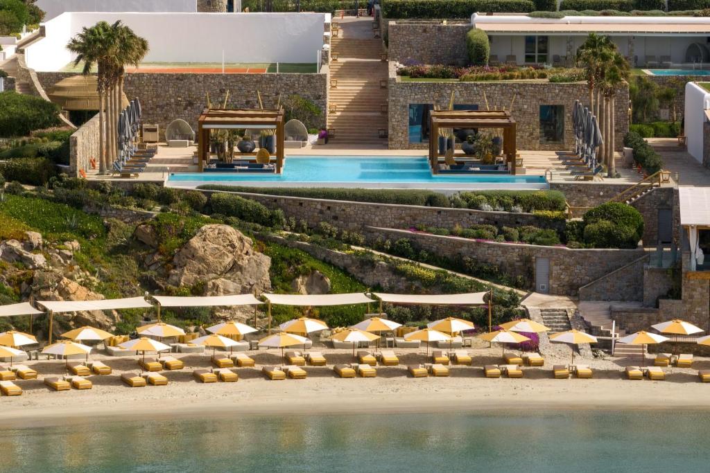 Luxurious resort with pools and sun loungers overlooking the beach.
