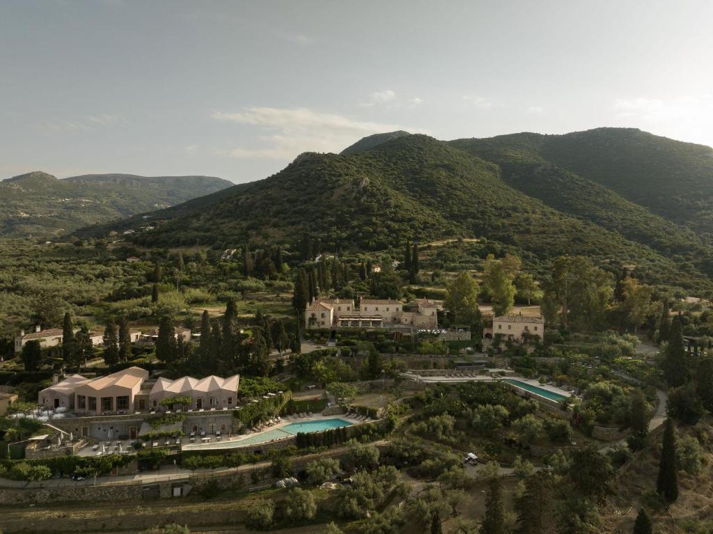 Scenic landscape with hills, greenery, and buildings under a cloudy sky.