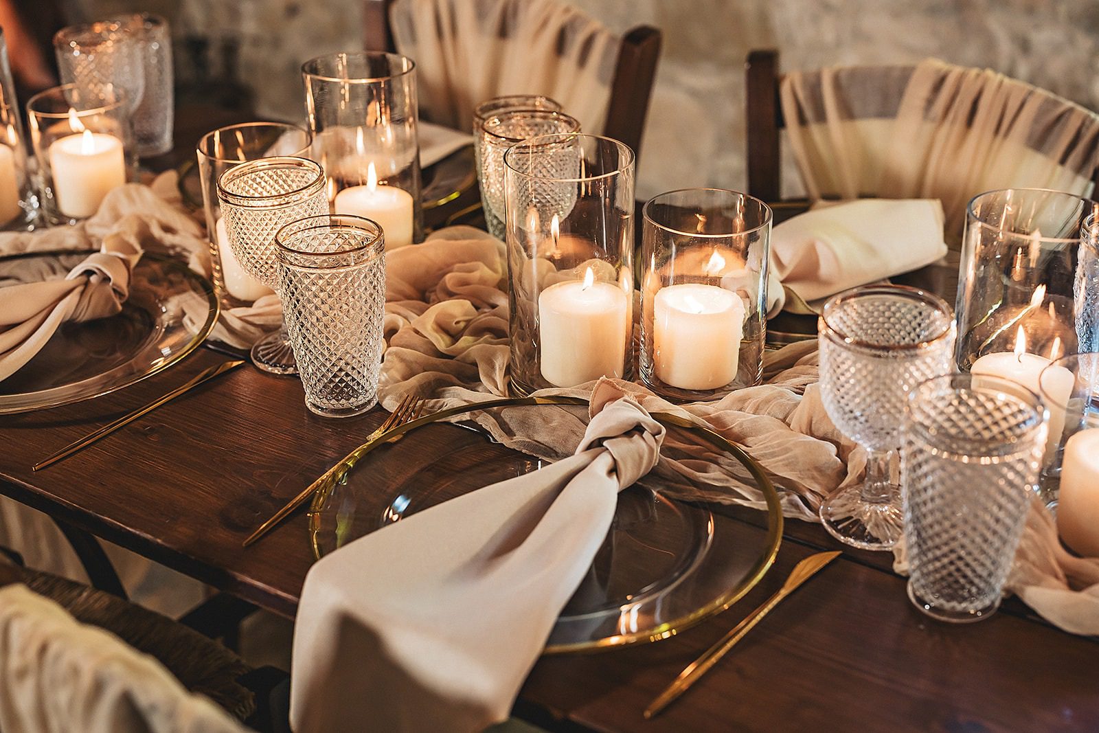 Elegant table setting with candles and glassware for a cozy dinner.