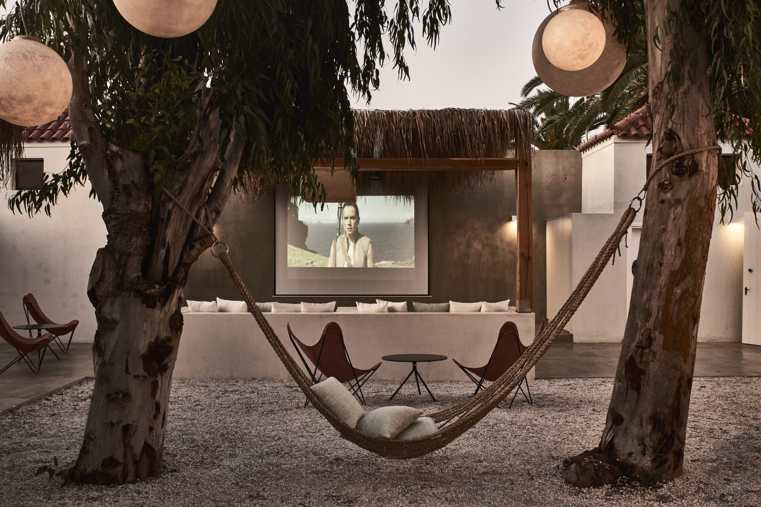 Cozy outdoor hammock seating under warm lighting at night.