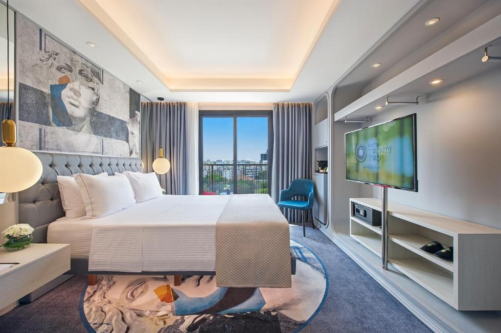 Modern hotel room with a large bed and city view.