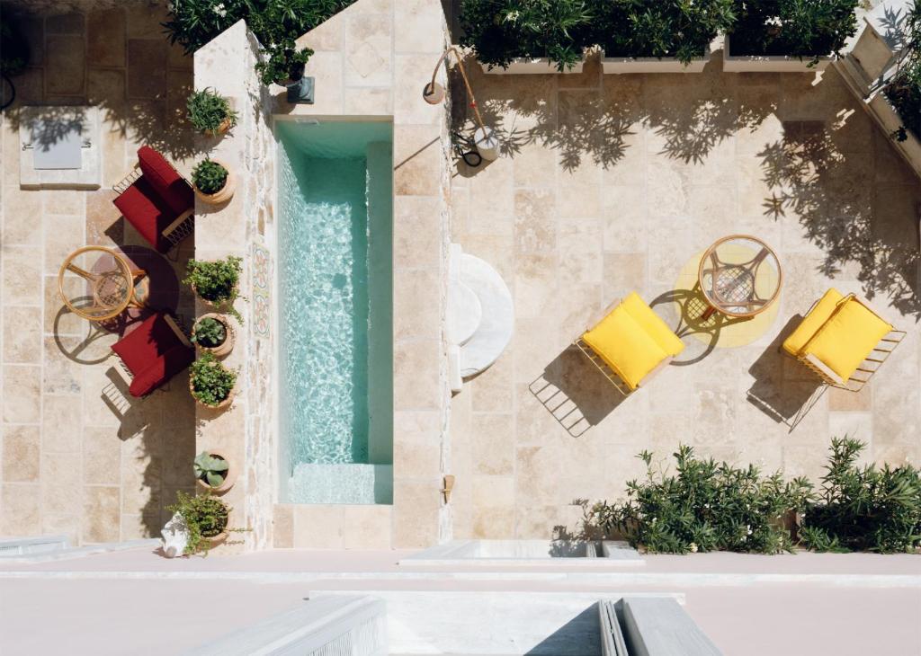 Cozy outdoor pool area with a yellow lounge chair and plants.