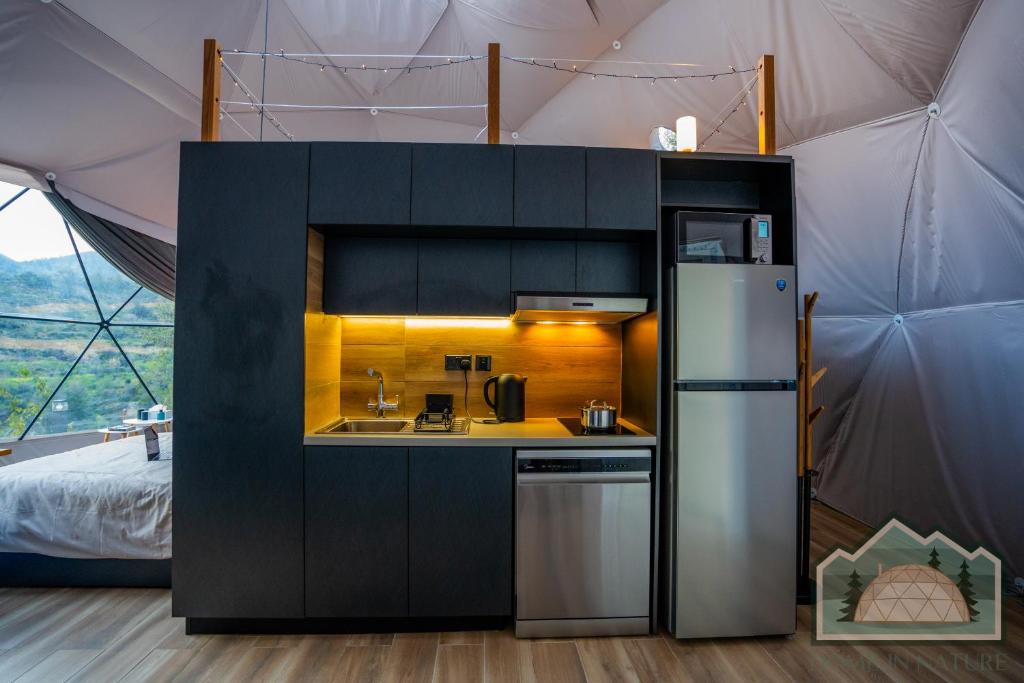 Compact modern kitchenette with black cabinets and warm lighting.