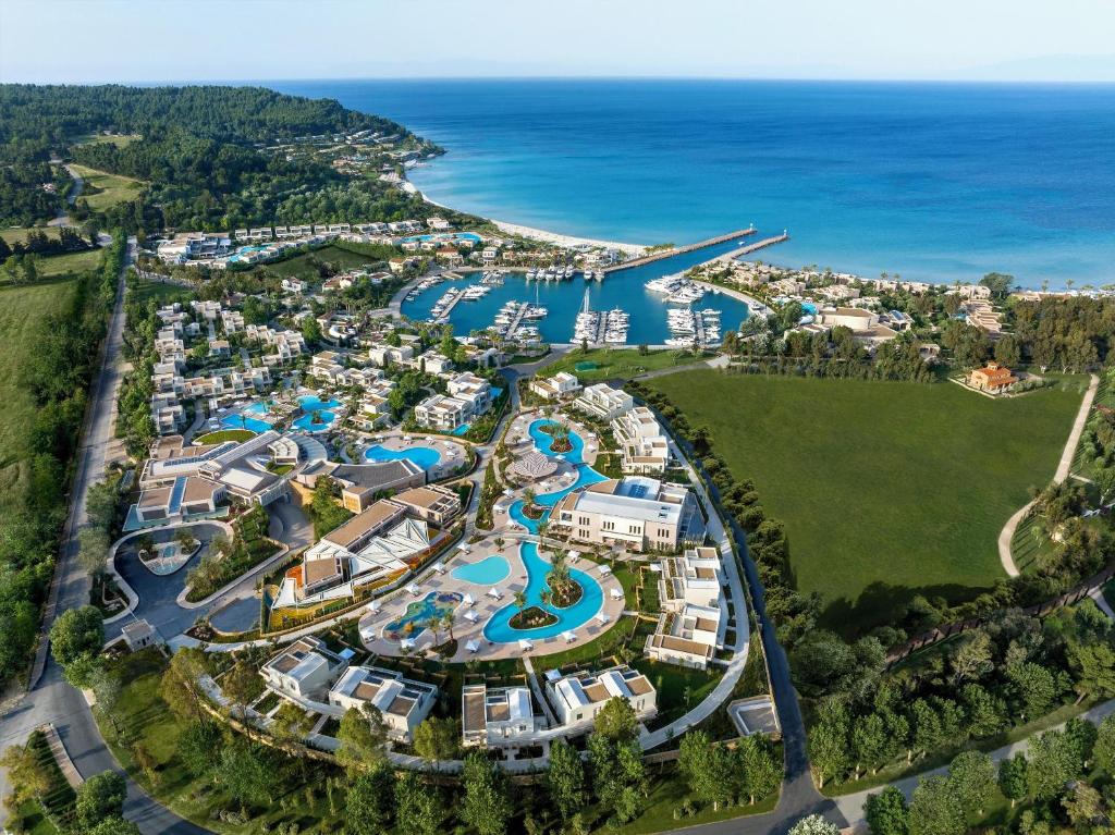 A coastal resort with pools, buildings, and a marina by the sea.