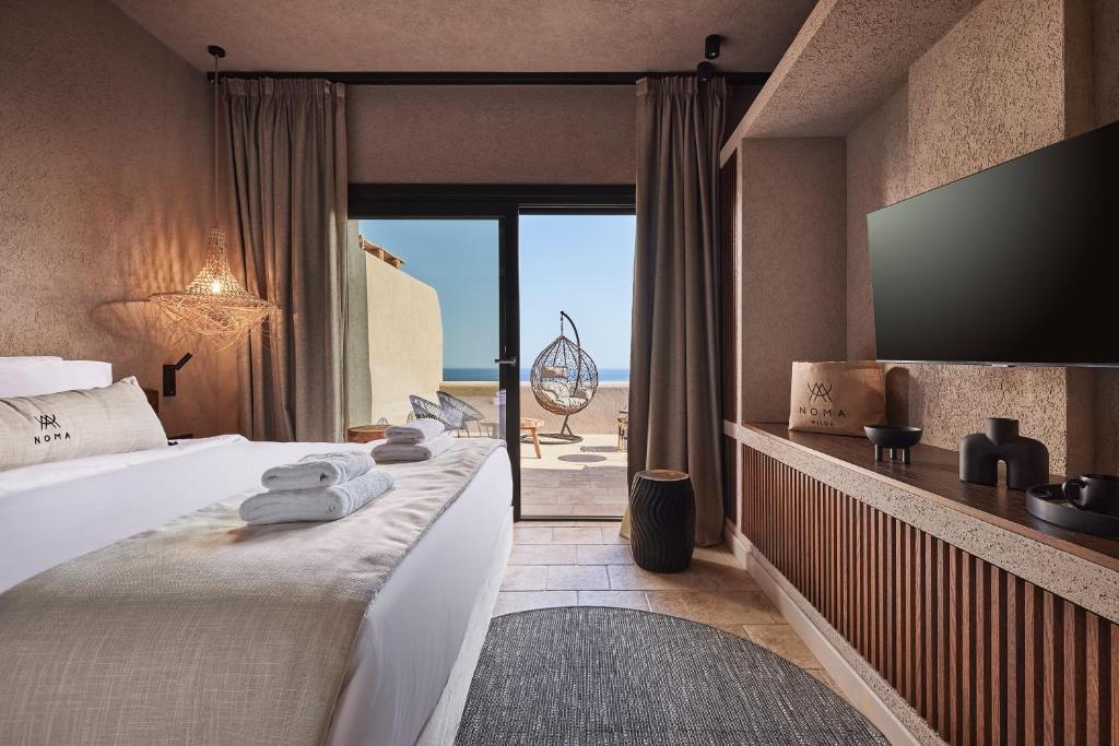 Modern bedroom with sea view and outdoor seating area.