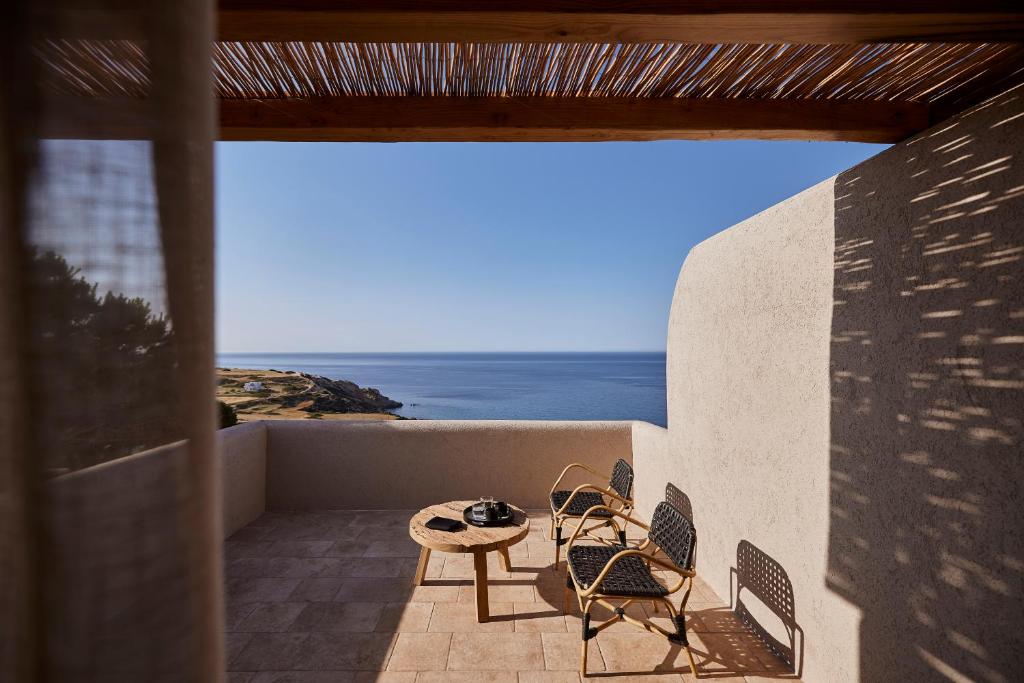 Cozy outdoor seating with ocean view under a shaded patio.
