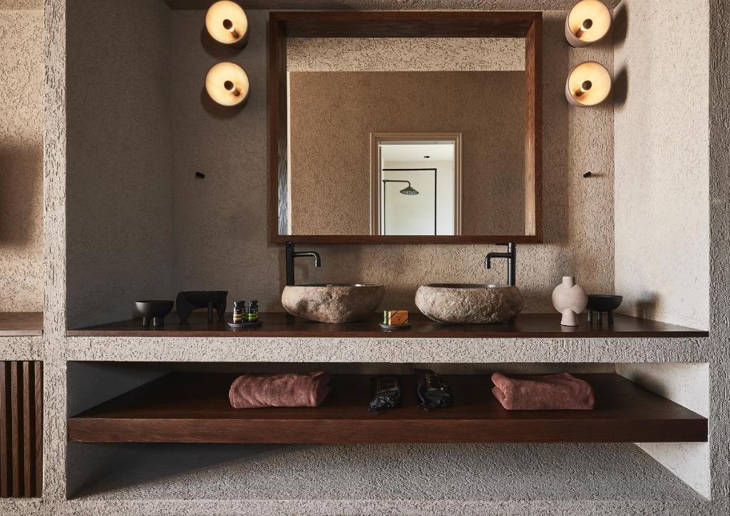 Modern bathroom with a large mirror and warm lighting.