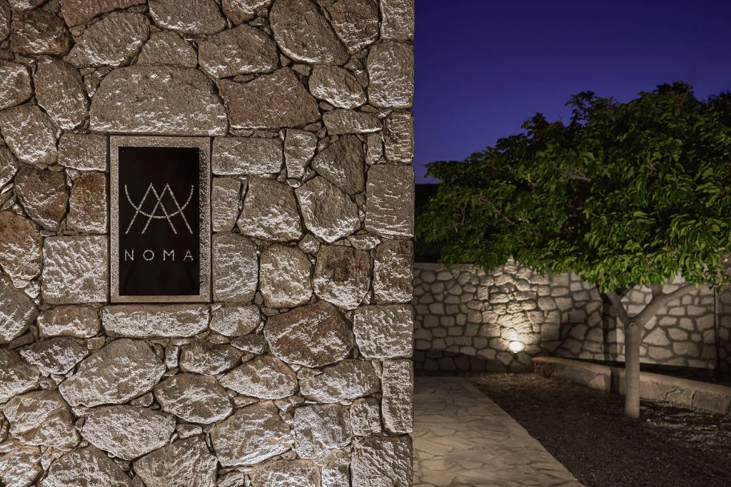 Elegant stone wall with a sign lit by soft lighting at night.