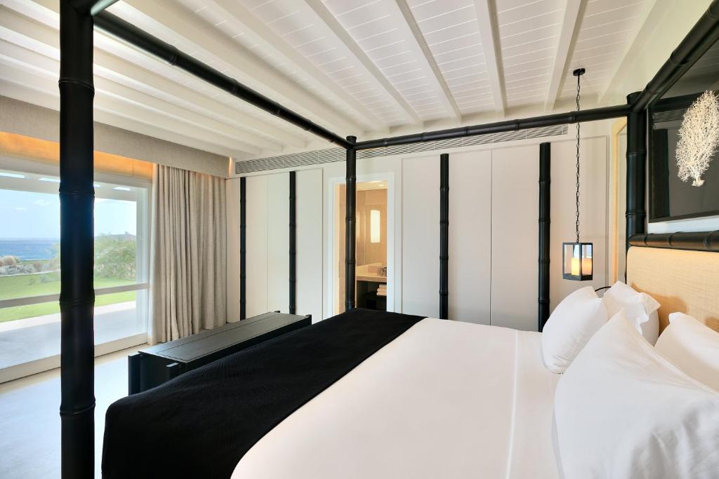 Modern bedroom with white and black decor and large wardrobe.