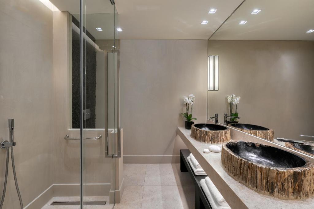 Modern bathroom with glass shower and elegant double sinks.