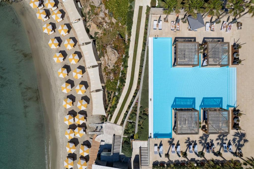 Aerial view of a pool and sun loungers with umbrellas at a resort.