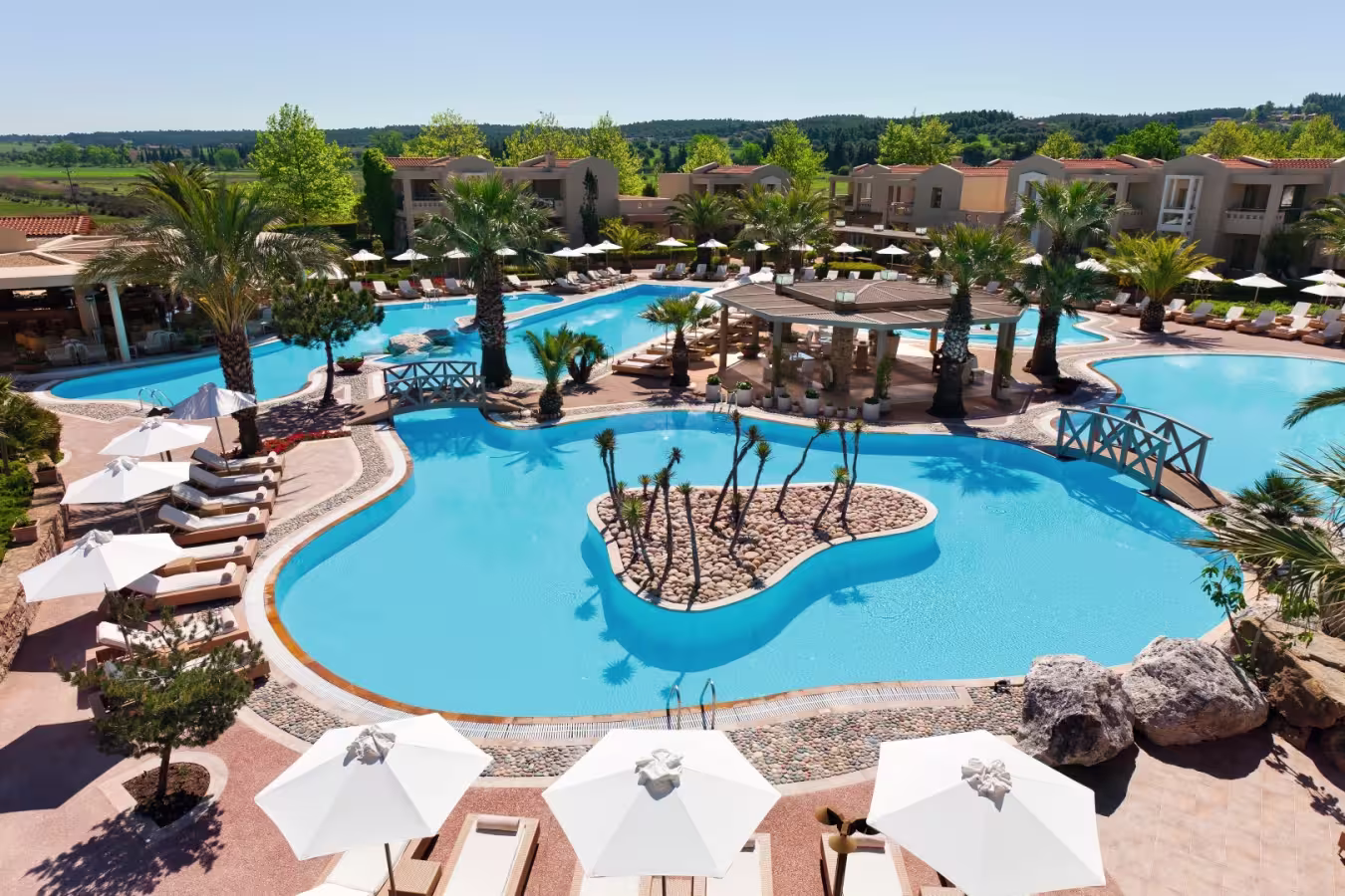 Luxurious outdoor pool area with sun loungers and umbrellas.
