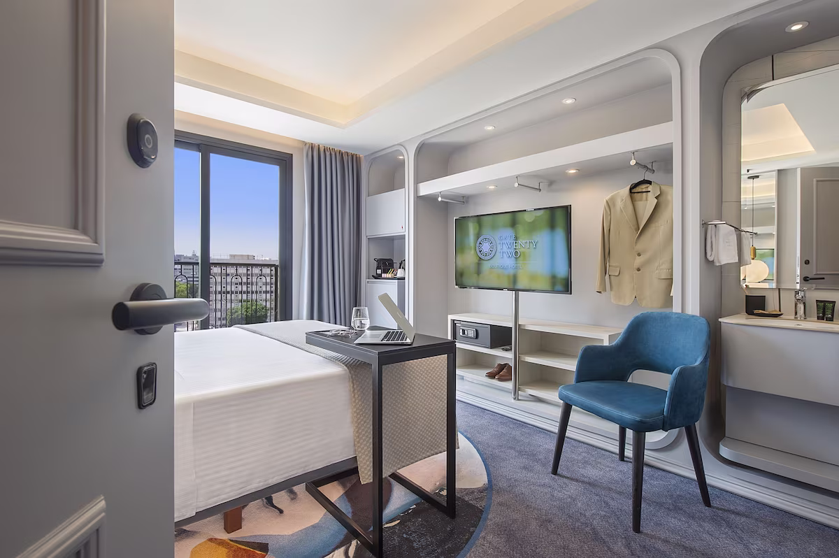 Modern hotel room with large window and stylish decor.