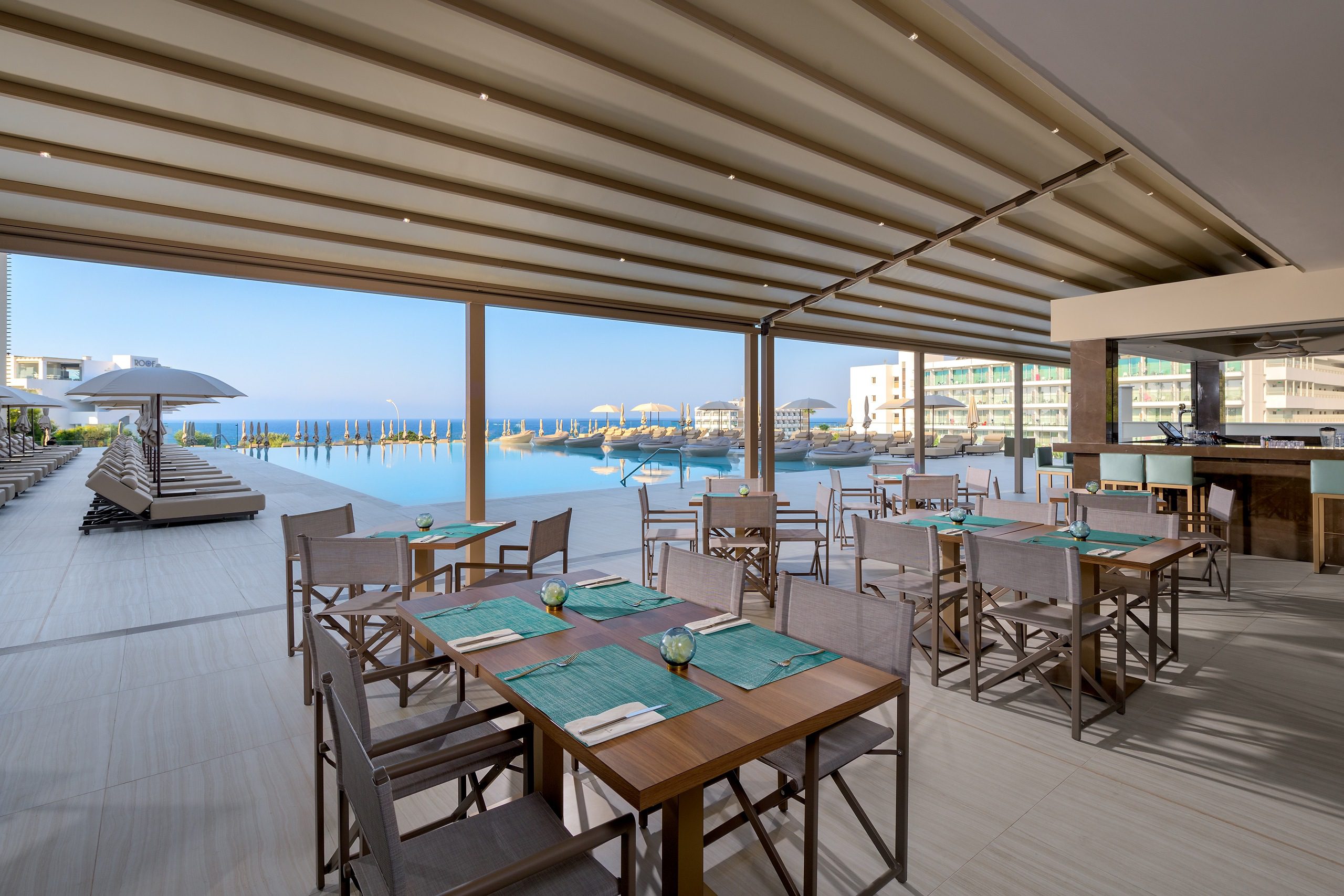 Open-air restaurant with sea views and modern decor.