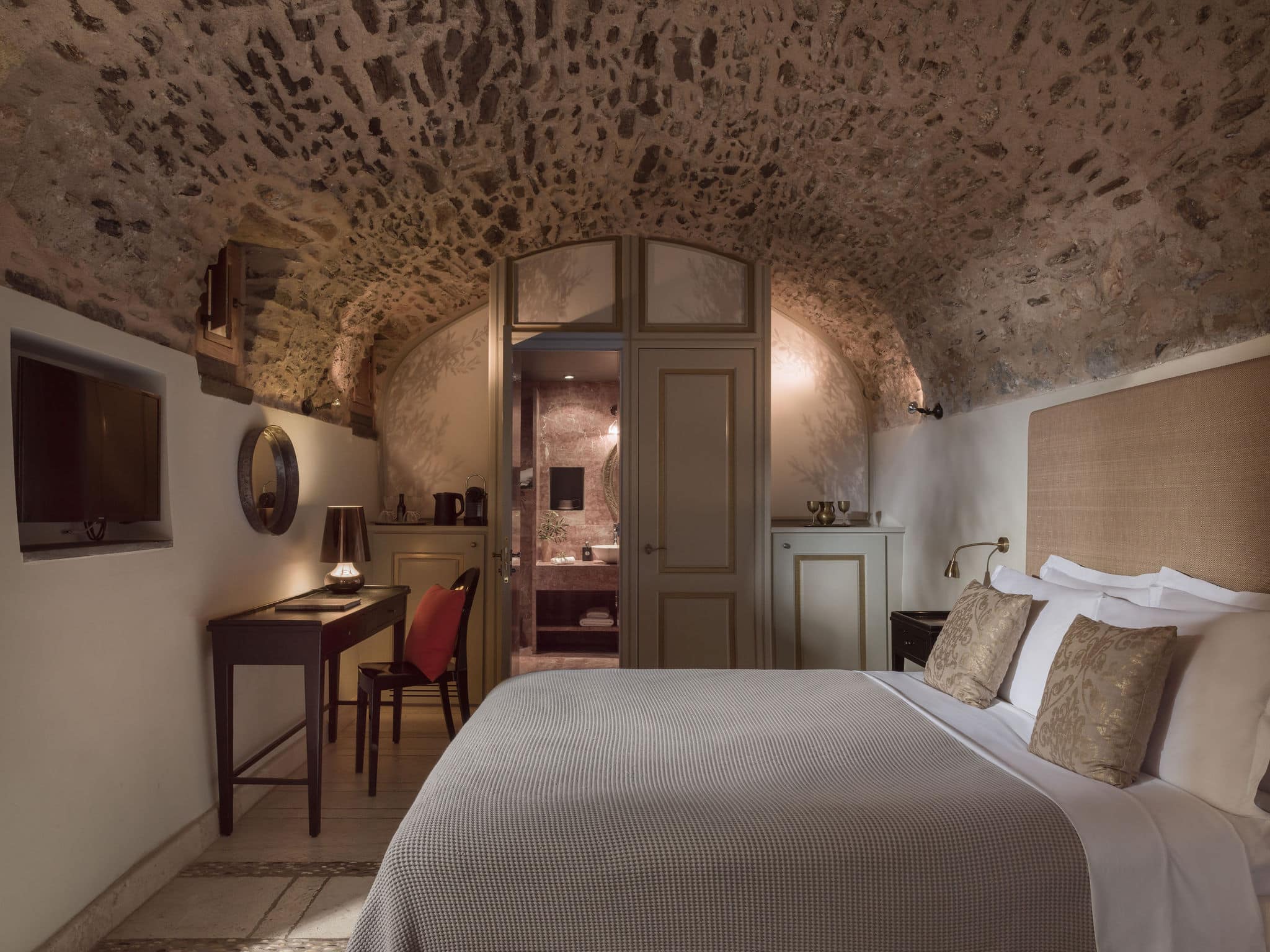 Cozy bedroom with stone vaulted ceiling and elegant decor.