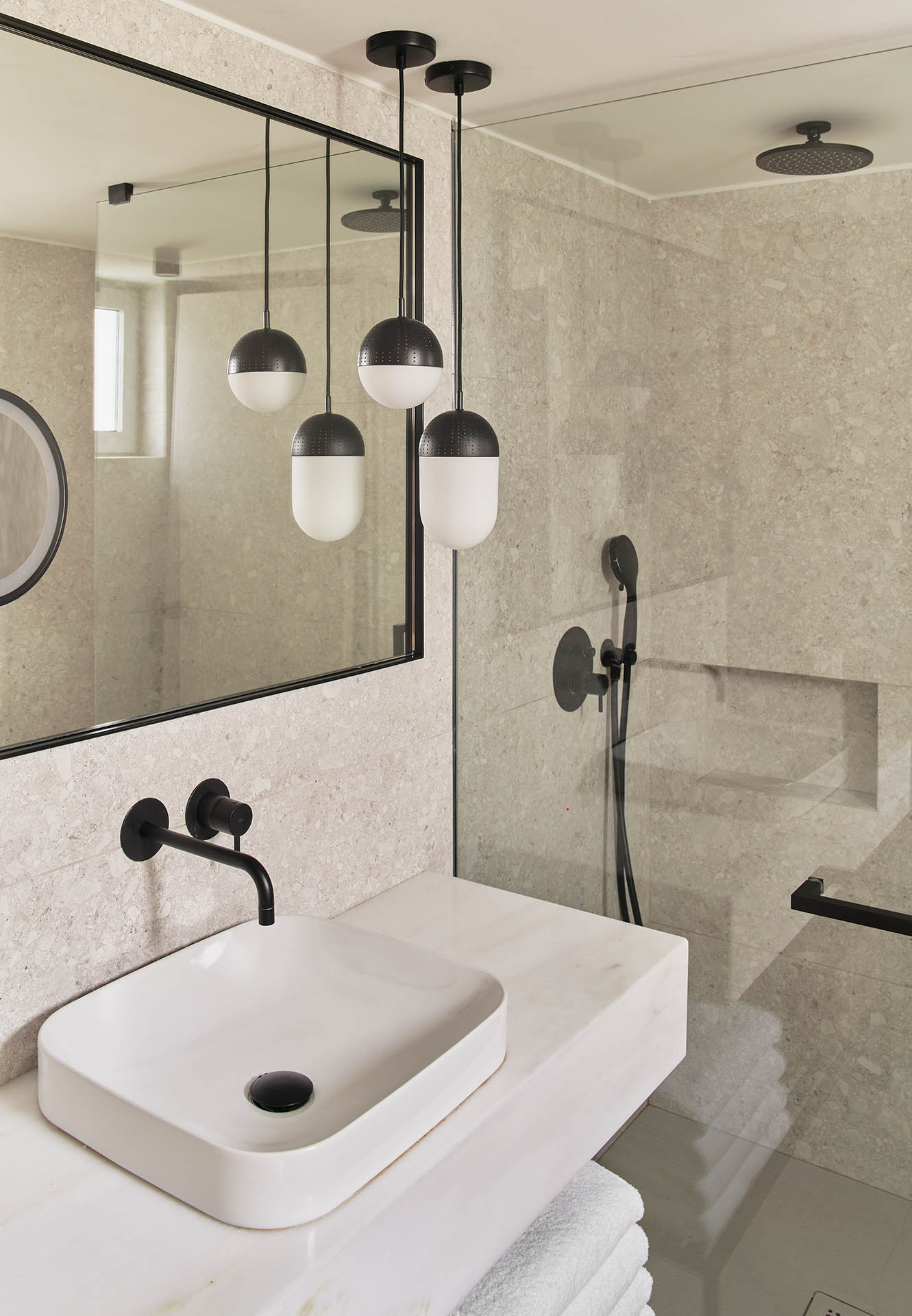 Modern bathroom with white sink and black fixtures.