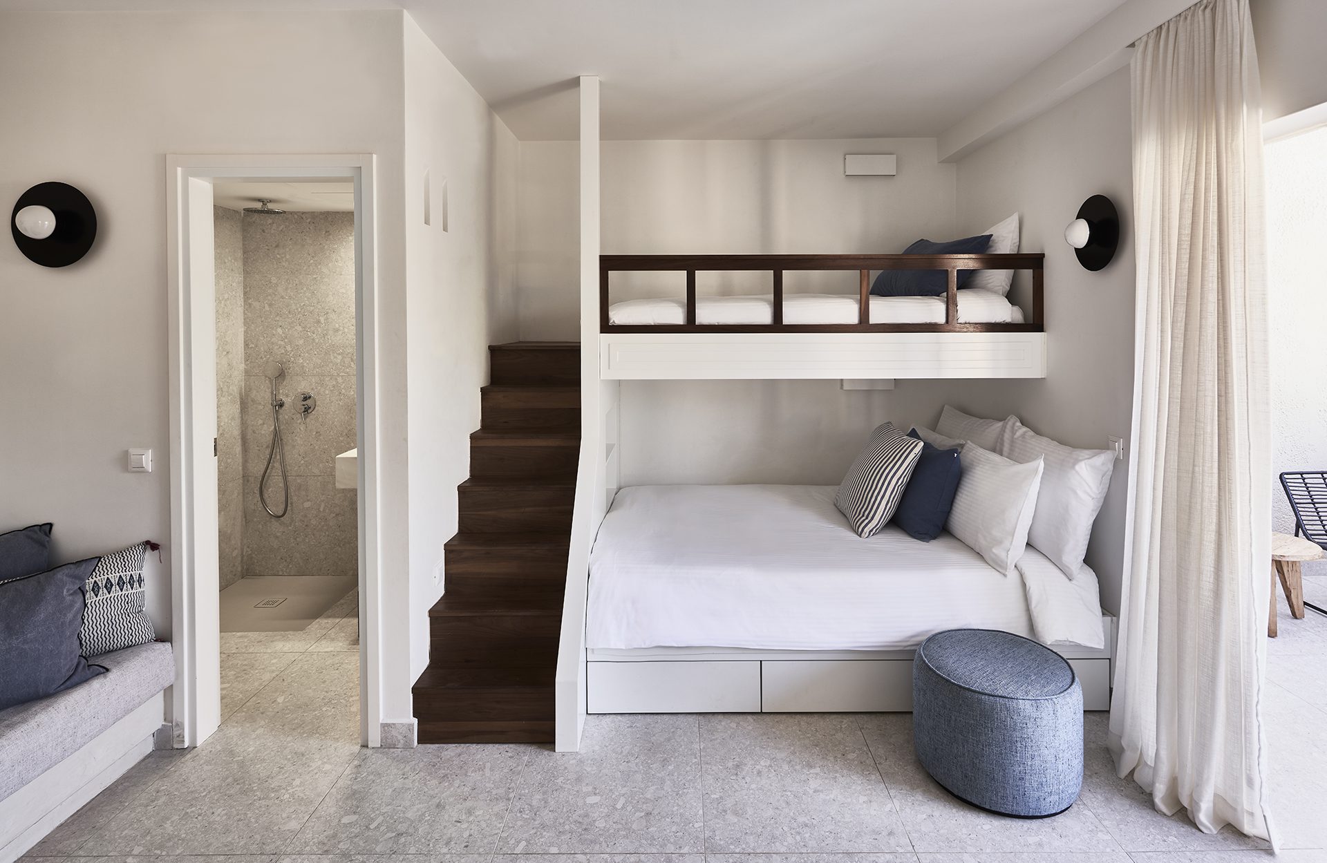 Modern compact bedroom with bunk beds and a small bathroom.