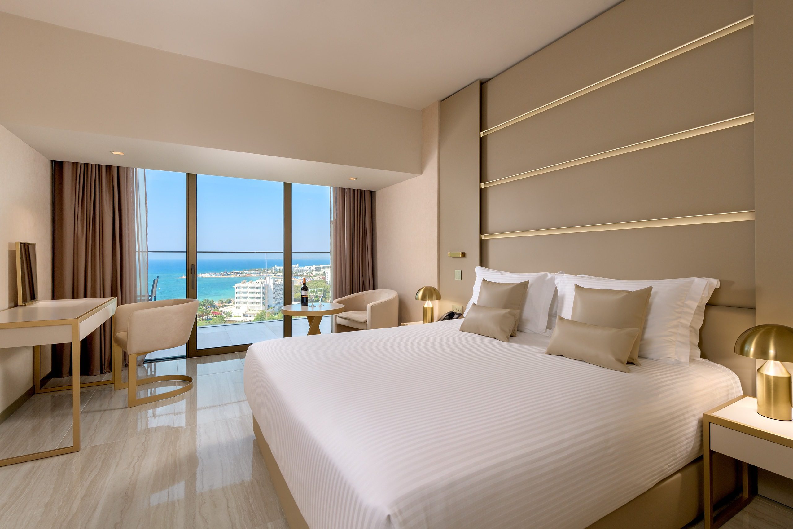 Modern bedroom with ocean view and neutral tones.