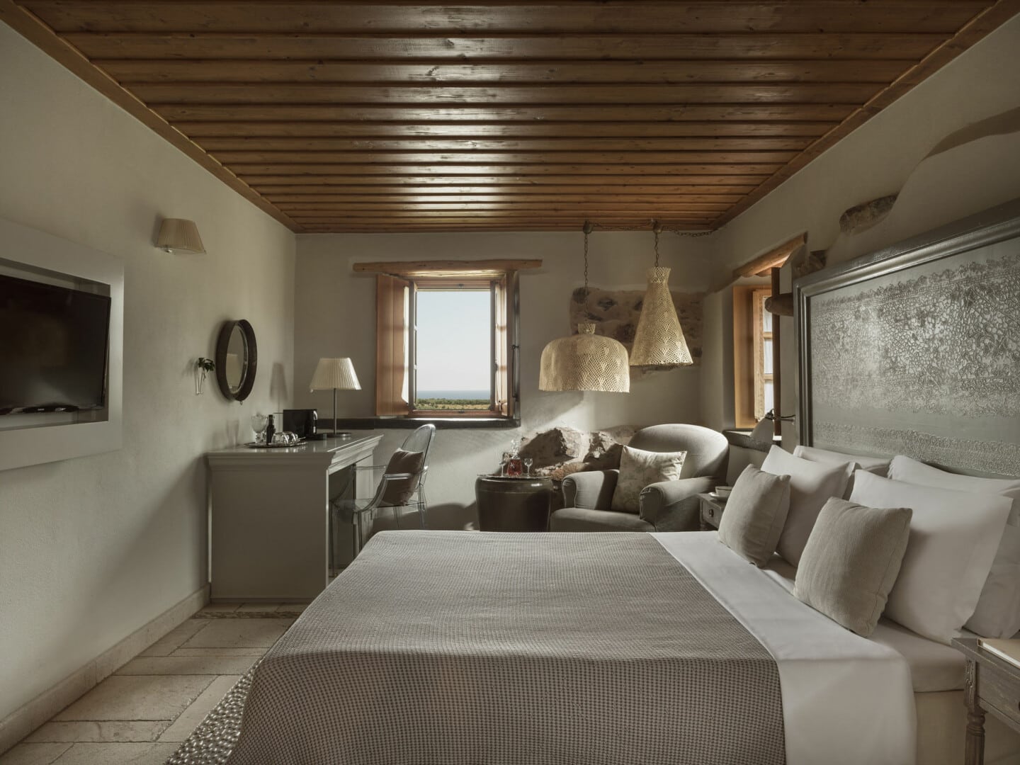 Cozy rustic bedroom with wooden ceiling and neutral tones.