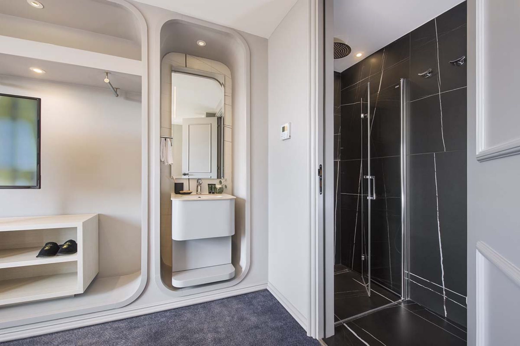 Modern bathroom with sleek shower and integrated sink unit.
