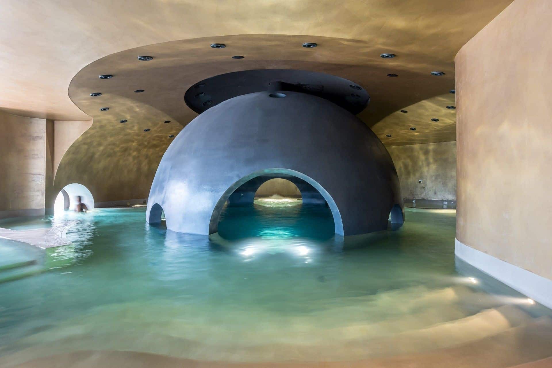 A futuristic dome structure in a serene water-filled space.
