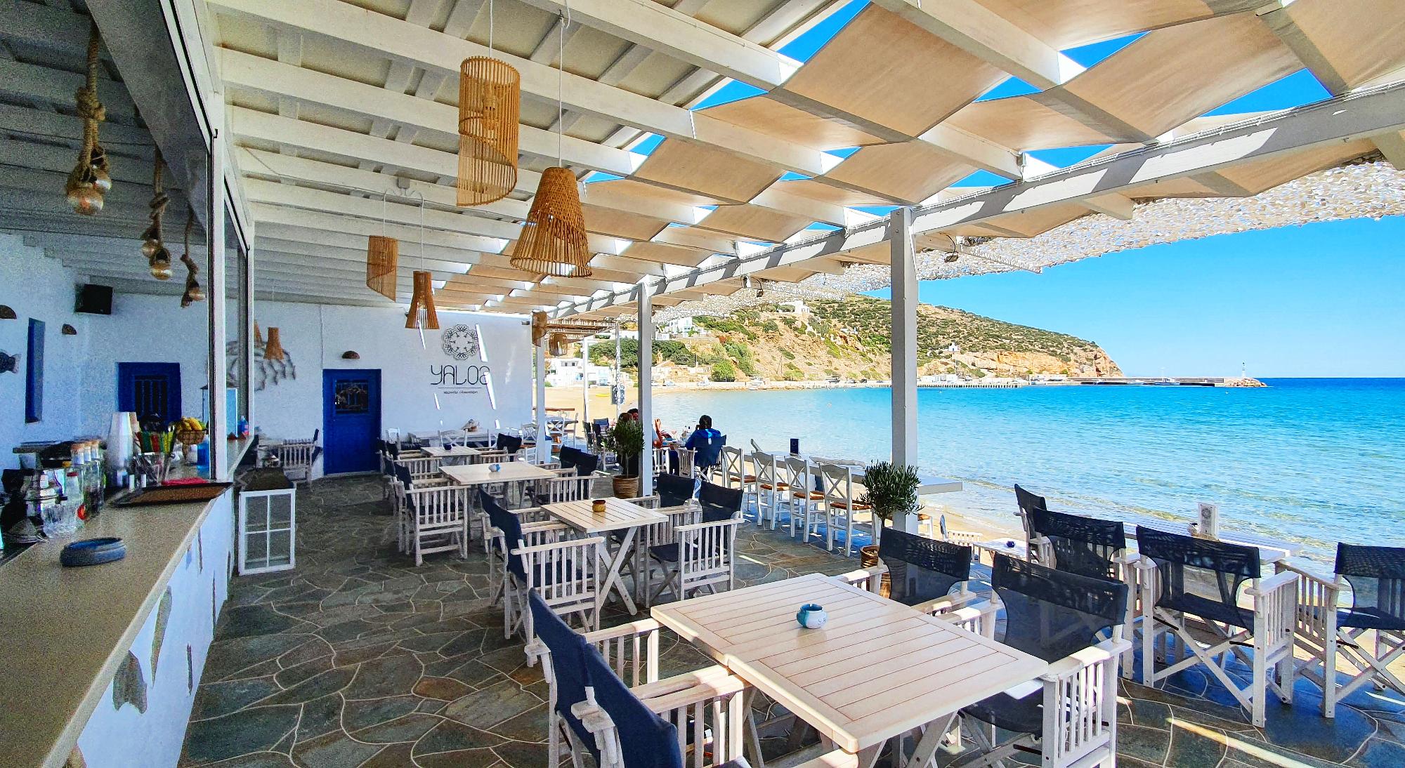 Cozy seaside restaurant with blue and white decor overlooking the ocean.