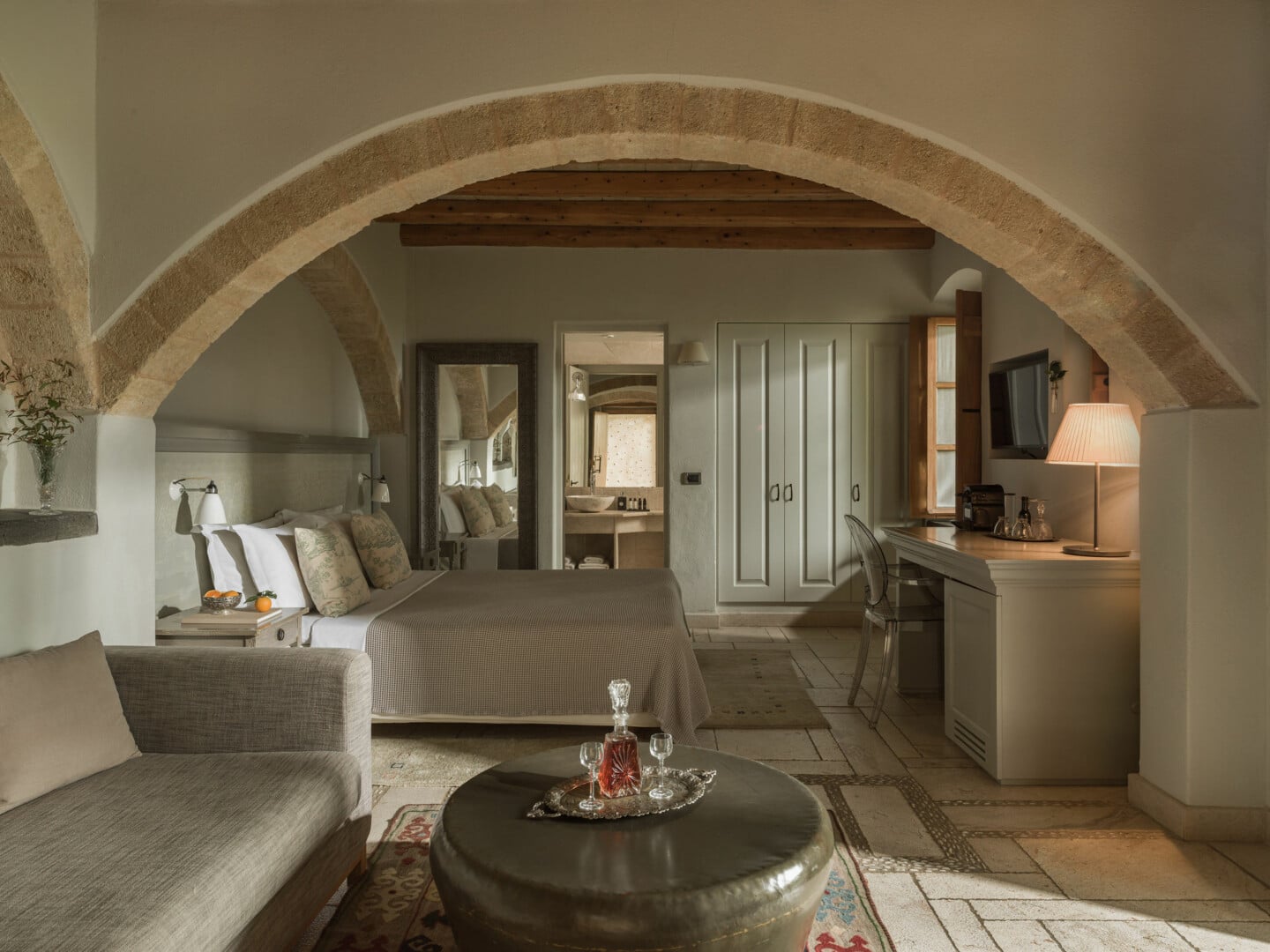 Cozy living room with neutral tones and rustic stone arch.