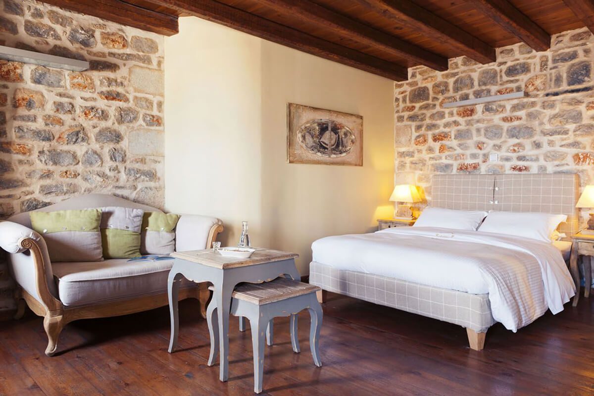 Cozy bedroom with rustic stone walls and elegant wooden furniture.